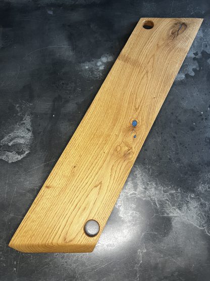 Longue planche apéritive avec incrustation d'epoxy bleu dans les veines et noeuds du bois